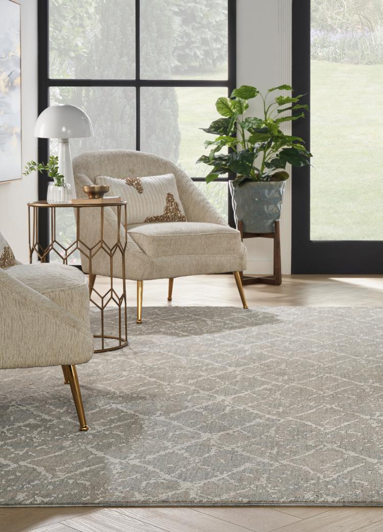 patterned grey carpet in living room with matching chairs and metal cabinet with mixed metal decor.